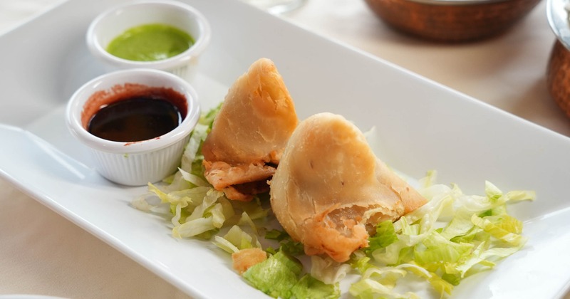 Samosa served on a plate with two dipping sauces