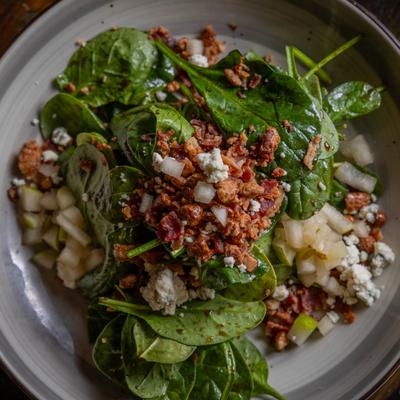 Pear and pecan salad with spinach, bacon, and cheese crumble.