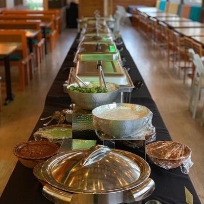 A long table with served catering food in a dining room.