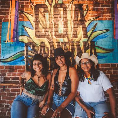Interior, three smiling guests by a decorated wall