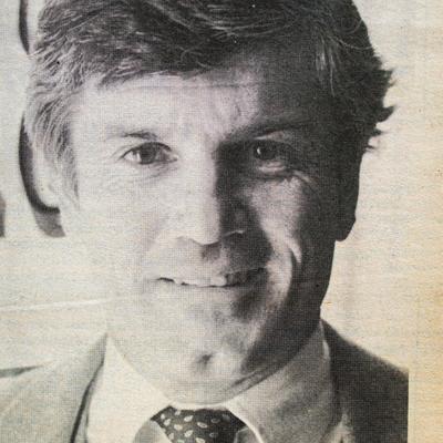 A black and white photo of a person in a suit