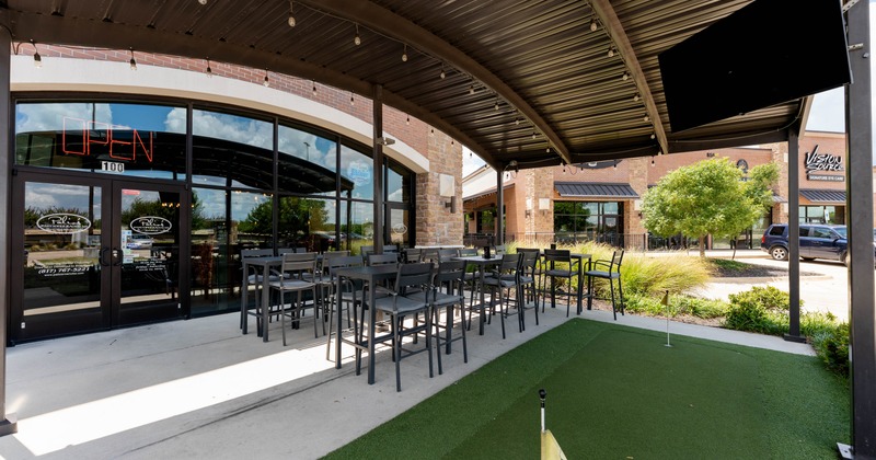 Exterior, restaurant front, covered high seating area, mini golf grass patch