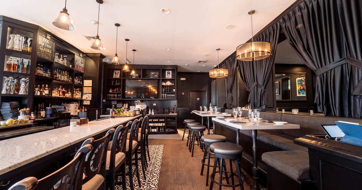 Interior, bar area, bar and bar stools on the left, tables and benches on the right