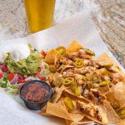 Blackened chicken nachos, with jalapenos, cheese, ranch, salsa, guacamole, and sour cream.