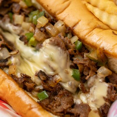 Philly sandwich layered with melted cheese, close up.