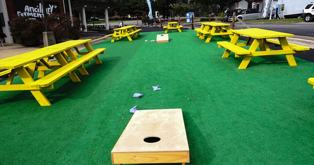 Exterior, green carpet, mini golf terrain between  benches and tables