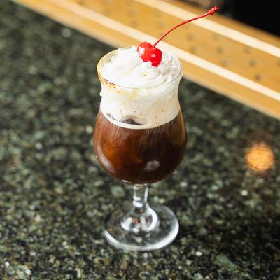 Cafe Pierre cocktail, topped with whipped cream and a cherry
