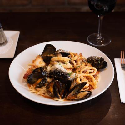 Mussels calamari pasta with a glass of red wine.