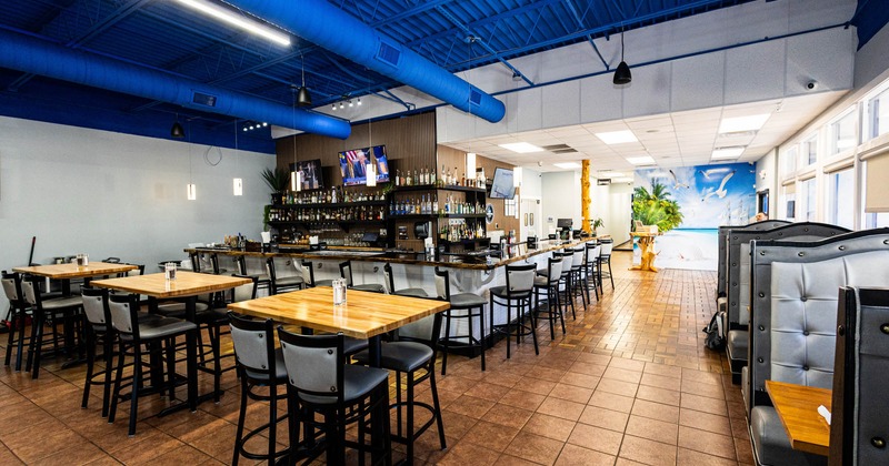 Interior, bar area, bar with stools, high seating tables for four, booths on the right