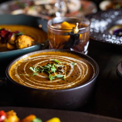 Slow cooked lentils with cream drizzle bowl, served with assorted dishes