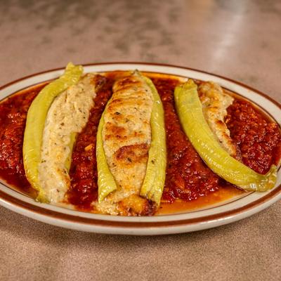 Stuffed banana peppers over tomato sauce.