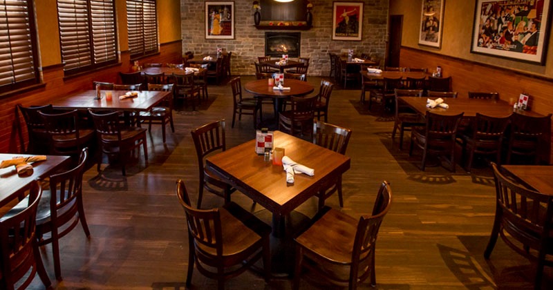 Dining area with wooden tables, stone fireplace, and wall art