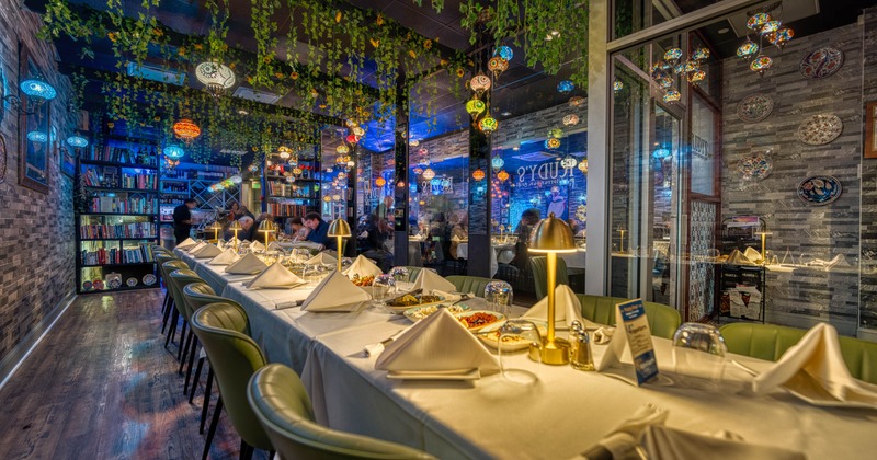 Dining space with leather chairs, tables and chandeliers