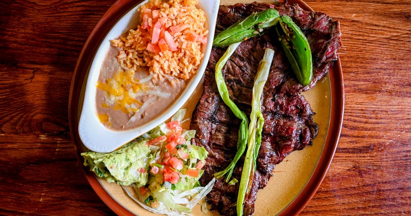 Carne Asada served with rice, refried beans, guacamole, picoo de gallo, and a jalapeno