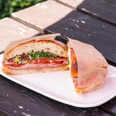 Italian Sub sandwich cut in half on an outdoor table.