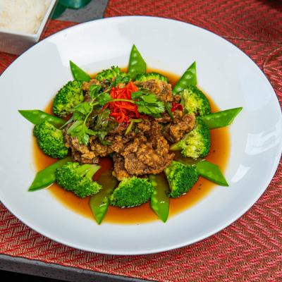 Citrus beef served with broccoli and snow peas.