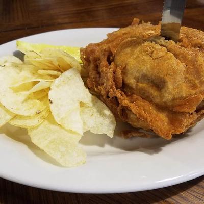 Fried chicken served with a side of potato chips.