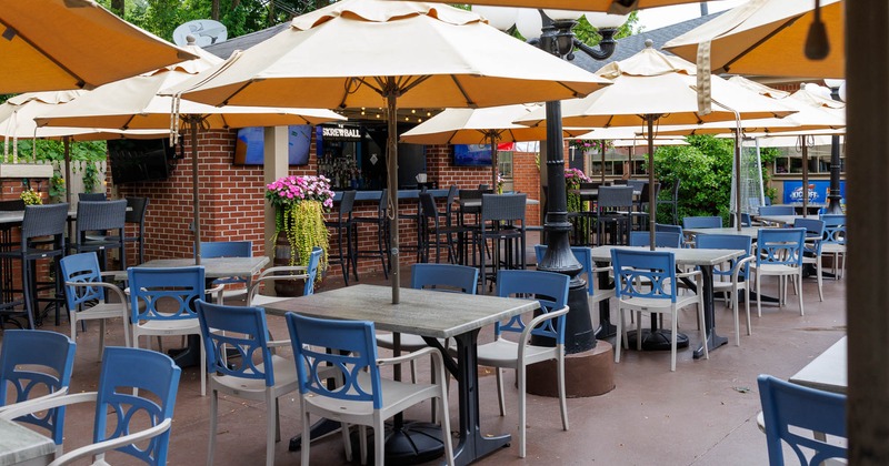 Outdoor seating area with tables, chairs and a brick bar