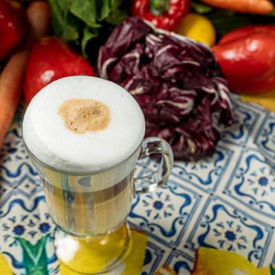 A drink and whole vegetables on display.