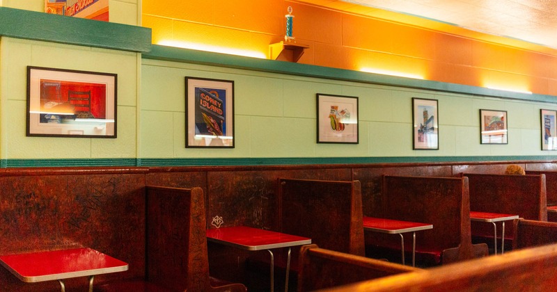 Interior, dining booths by a wall decorated with framed pictures