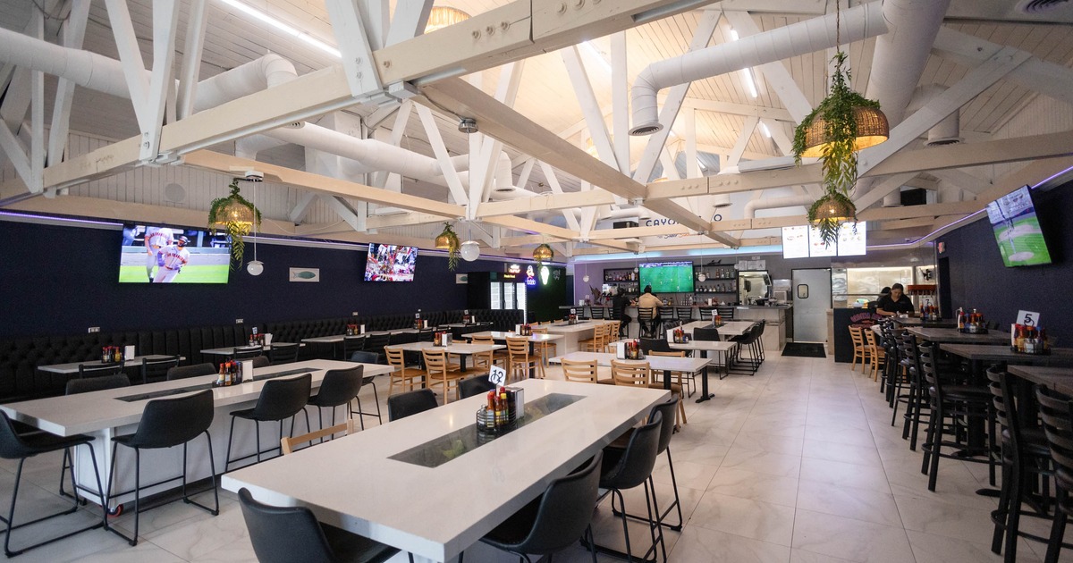 Modern restaurant interior with high ceilings, various seating options