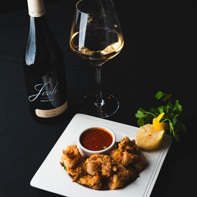 Fried calamari with marinara sauce, lemon, and parsley, accompanied by white wine.