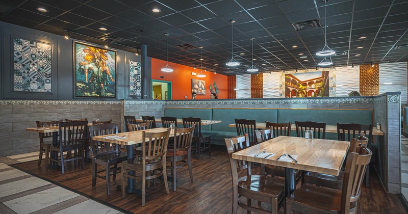 Interior, partitioned seating area with dining tables and banquette seating
