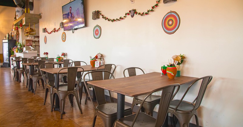 Interior, tables and chairs ready for guests, TV on the wall and wall decoration