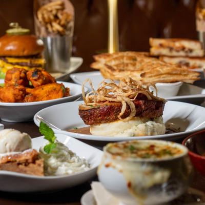 Meatloaf with mashed potatoes and crispy onions surrounded by  plated dishes.