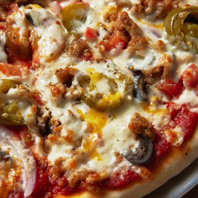 Pizza with sausage and jalapenos, close up view.