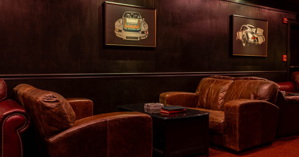 Interior, lounge area, two seater sofas with table, wood coated walls, framed pictures