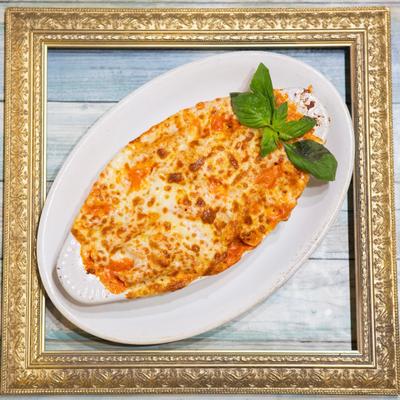 Baked Ziti garnished with basil, top view.