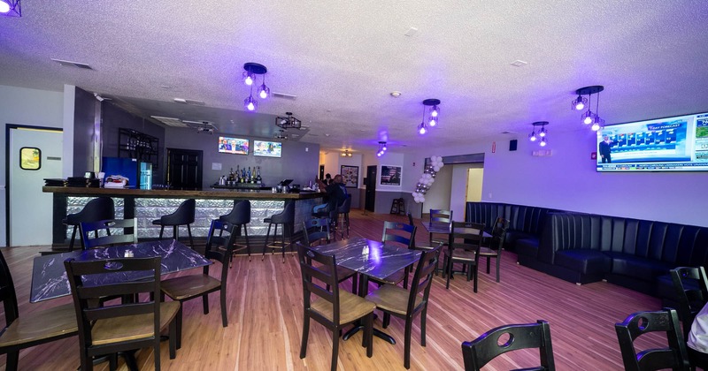 Interior, seating area and bar area, tables for four, bar with stools, seating booths