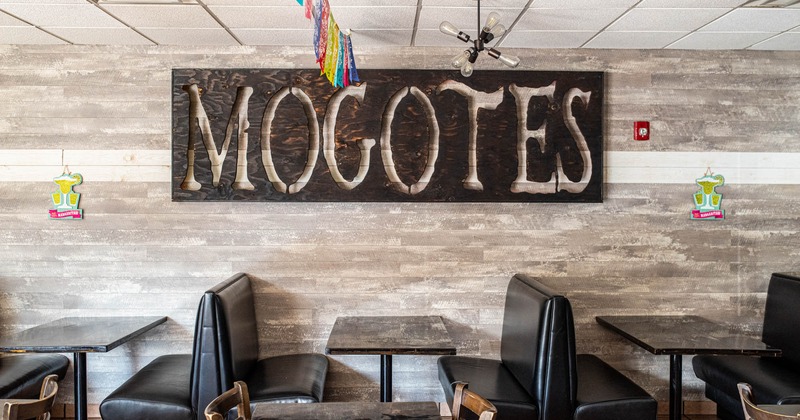 Interior, booths by a wall with Mogotes sign
