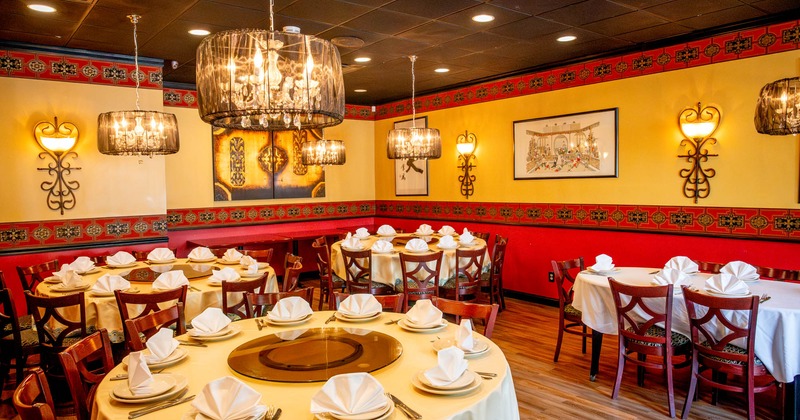 Interior, dining area,  round white cloth tables for twelve, ready for guests