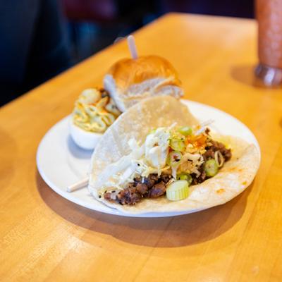 BBQ style taco served with a deviled egg and a slider.