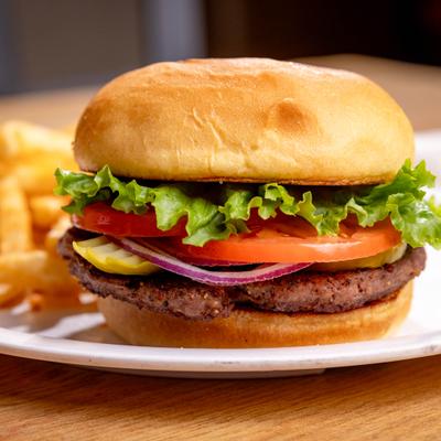 Burger with lettuce, tomatoes, and red onions.