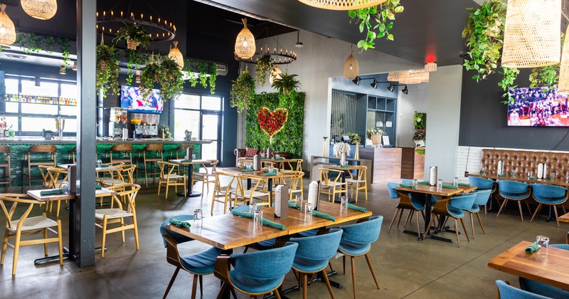 Interior, diner tables, armchairs, bar and booths behind