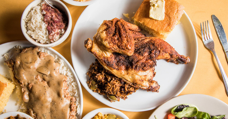 Roast whole chicken with dirty rice and cornbread served among other dishes
