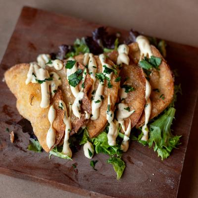 Stuffed fried dumplings, topped with sauce.