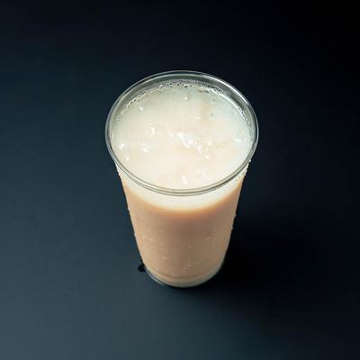 A cup of horchata on a black table, top view.