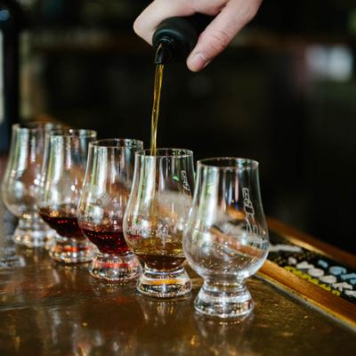 Bartender pouring drinks into glasses, closeup.
