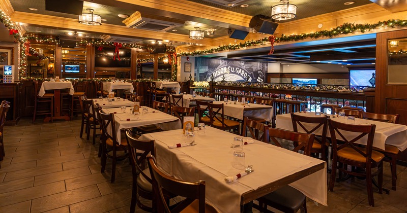 Interior, upstairs dining area, tables for four ready for guests, balcony railing, lanterns