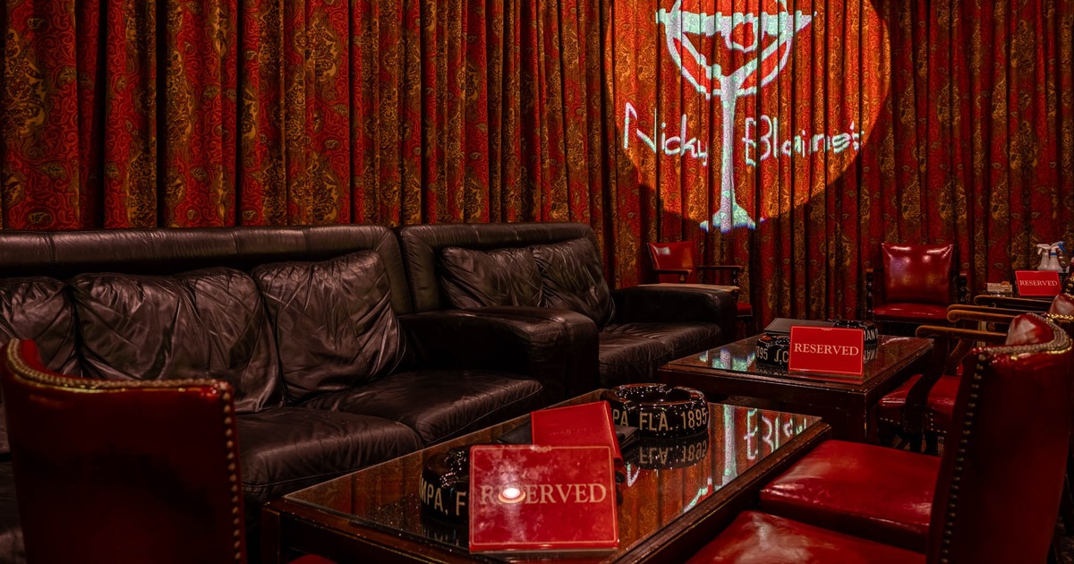 Interior, lounge area, sofas and armchairs with tables, spotlight with lounge's logo