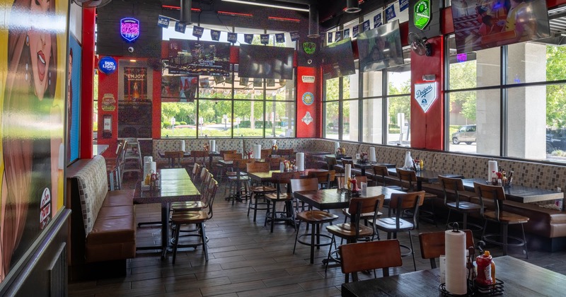 Interior, dining area, tables with chairs, ready for guests, tile flooring, TV sets on the walls