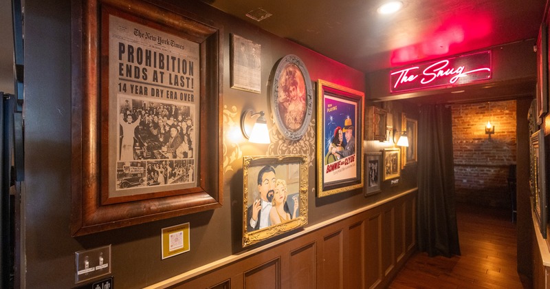 Posters, pictures, framed photos on the hallway wall, a lighted sign above