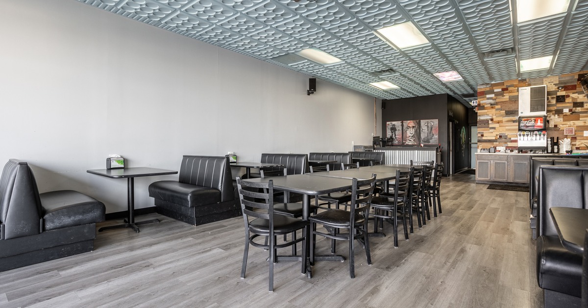 Specious interior seating area with a long table at the center and booths along the walls