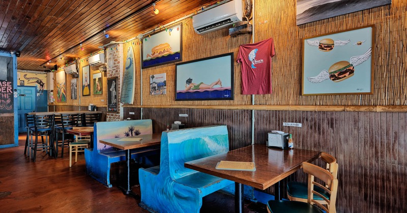 Interior, dining booths and tables by a wall decorated with pop art paintings