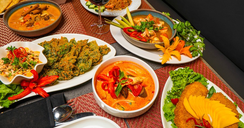 Various dishes served on a table with a glass of red wine