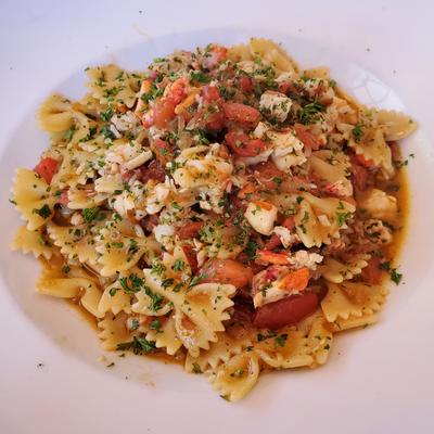 Bowtie pasta mixed with tomatoes and grated cheese.